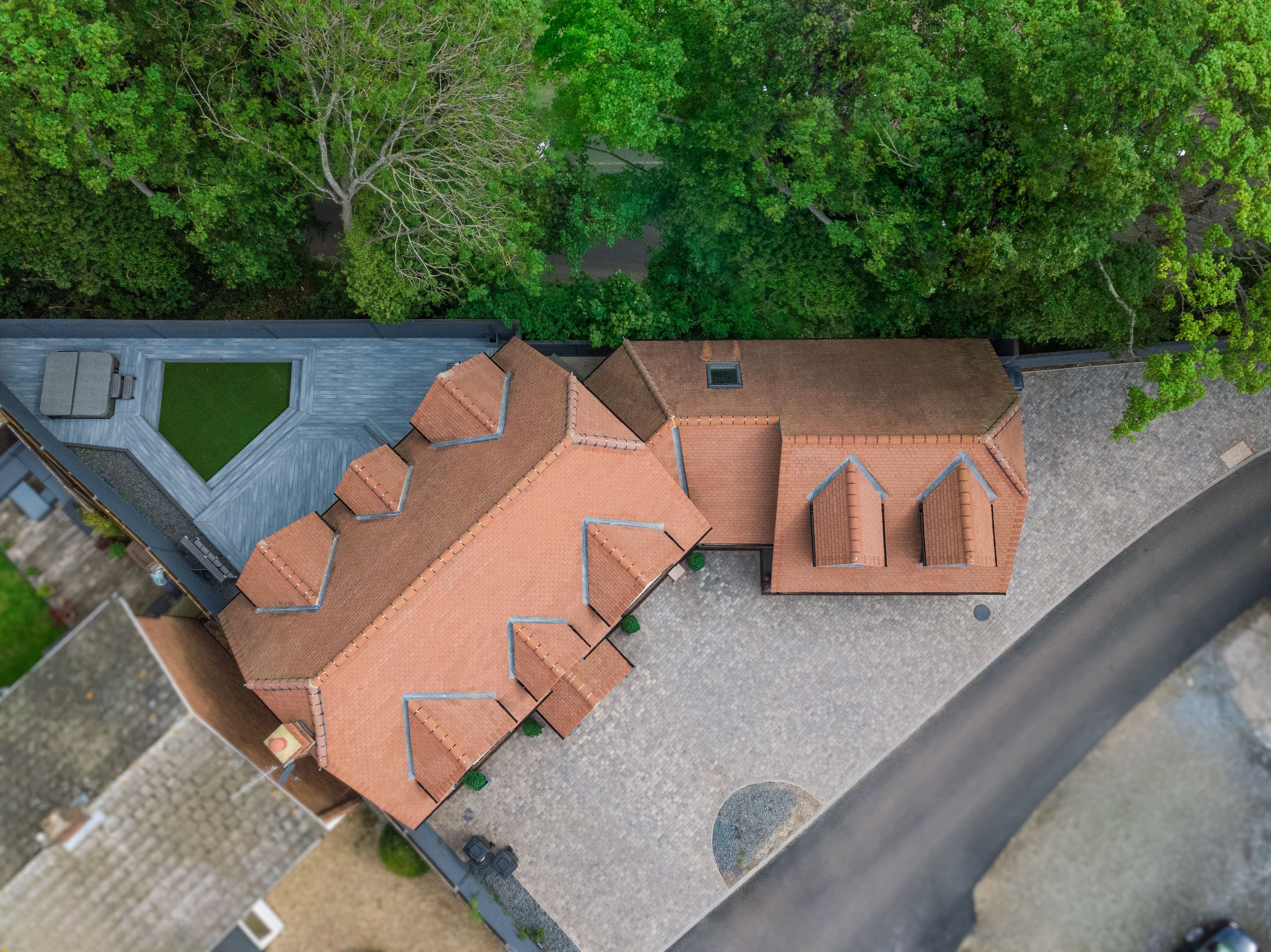 Aerial shot showcasing a residential area with distinctive roofs and lush greenery in Colchester, England.