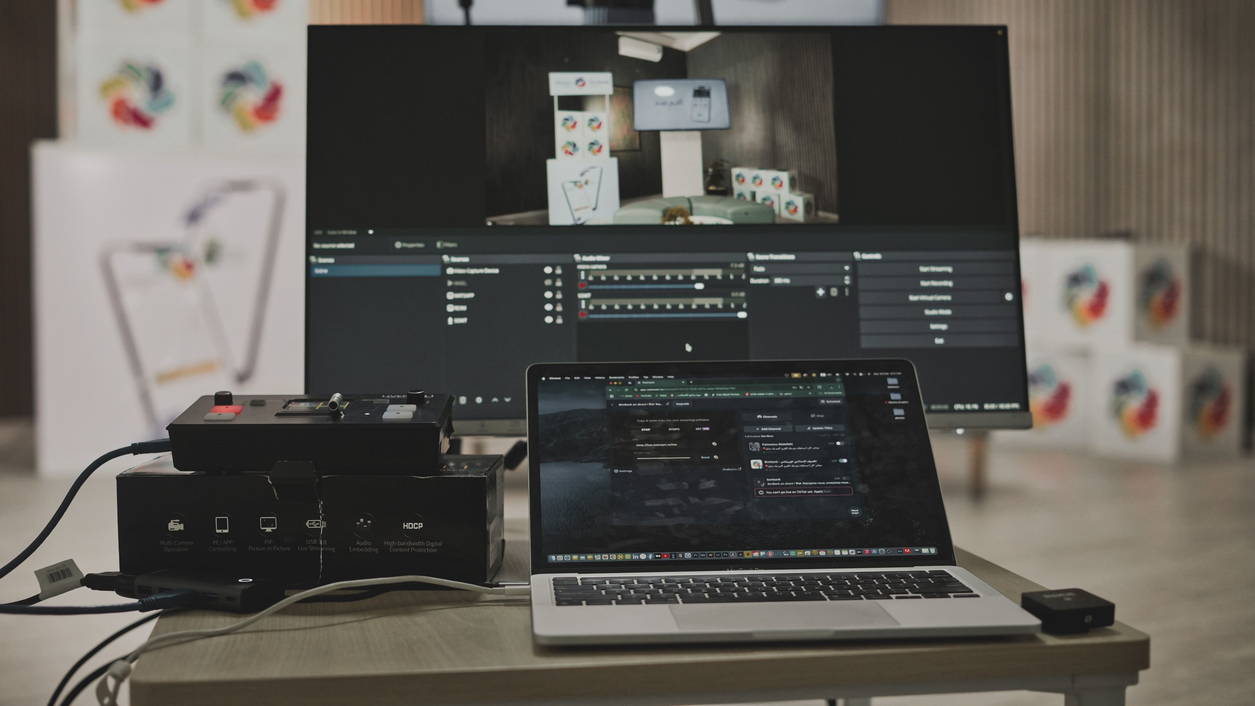 Multimedia setup featuring a laptop and a large monitor in a tech-savvy workspace.
