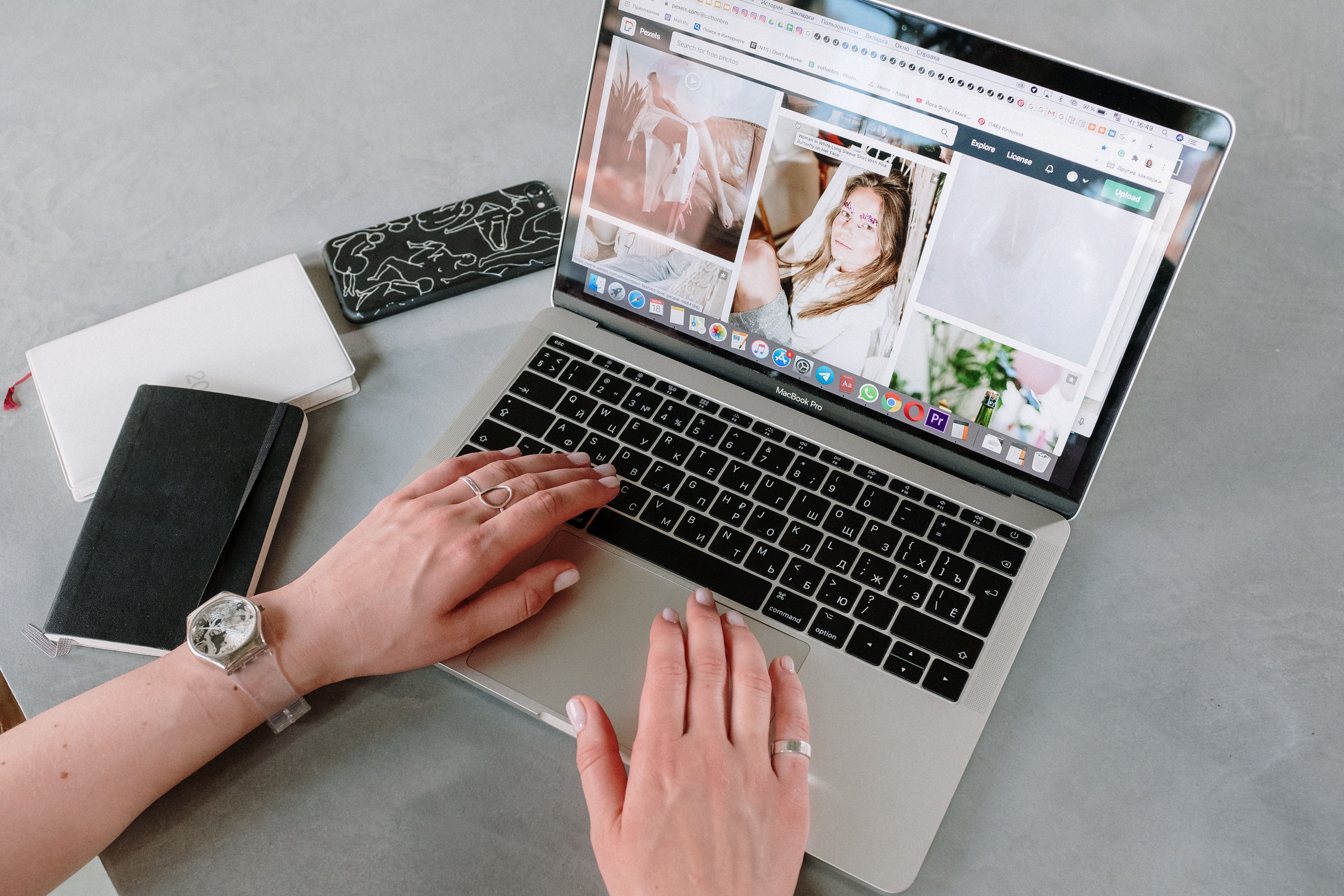 Close-up of a woman browsing online images using a laptop at home, highlighting a creative workspace.