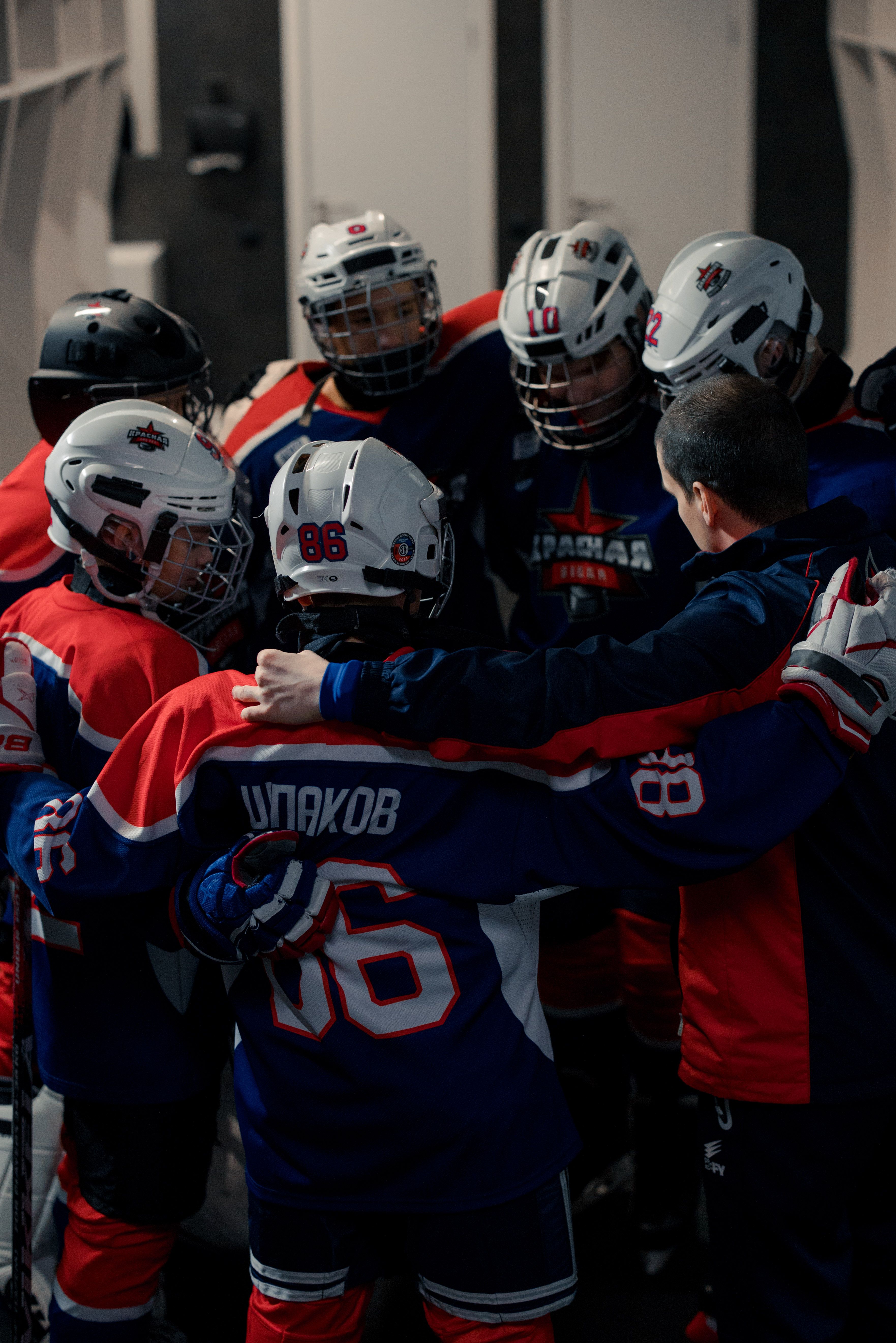 A youth hockey team gathers in a circle for a motivational huddle before a game.